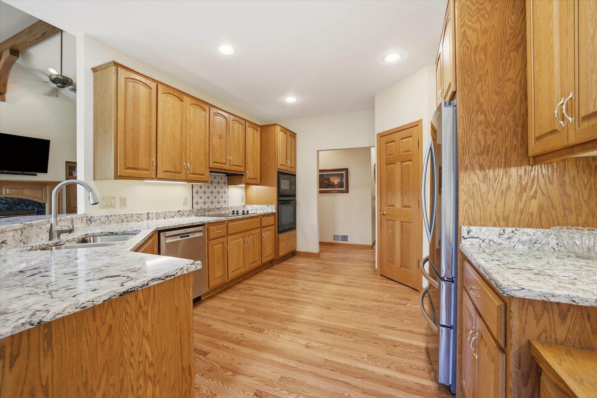W330-s1417 County Rd C Delafield, WI 53018 - Photo 10 of 39 Kitchen w/NEW Quartz Counters, SS Appliances, Wood Floors, & Pantry