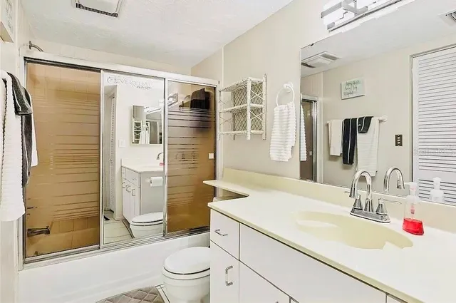 a bathroom with a sink toilet vanity and shower