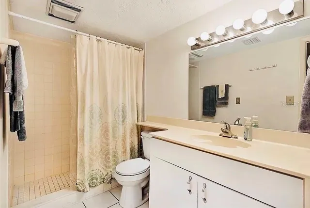 a bathroom with a sink a toilet and shower curtain