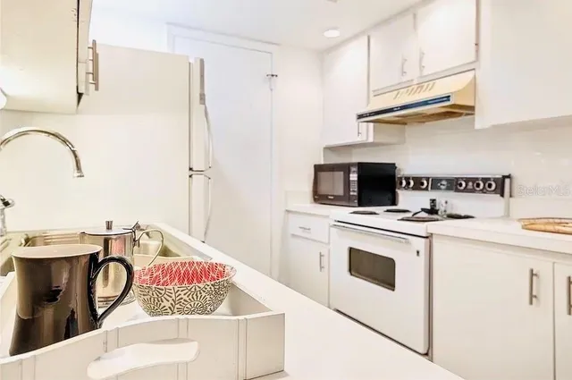 a kitchen with a stove and a white refrigerator