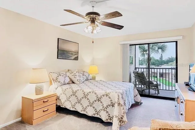 a bedroom with a large bed and a chandelier fan