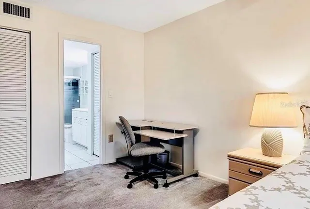 a view of a workspace with furniture and a window