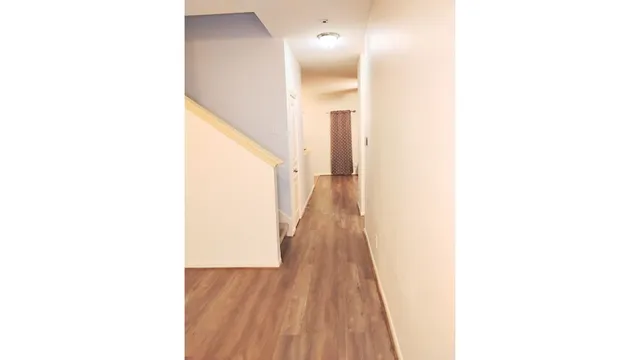 a view of a hallway with wooden floor