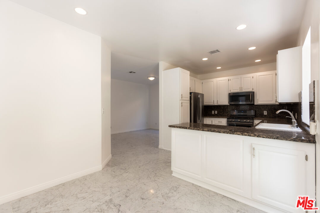 23636 Aster Trail Calabasas, CA 91302 - Photo 19 of 67 a kitchen with stainless steel appliances granite countertop a sink and a refrigerator