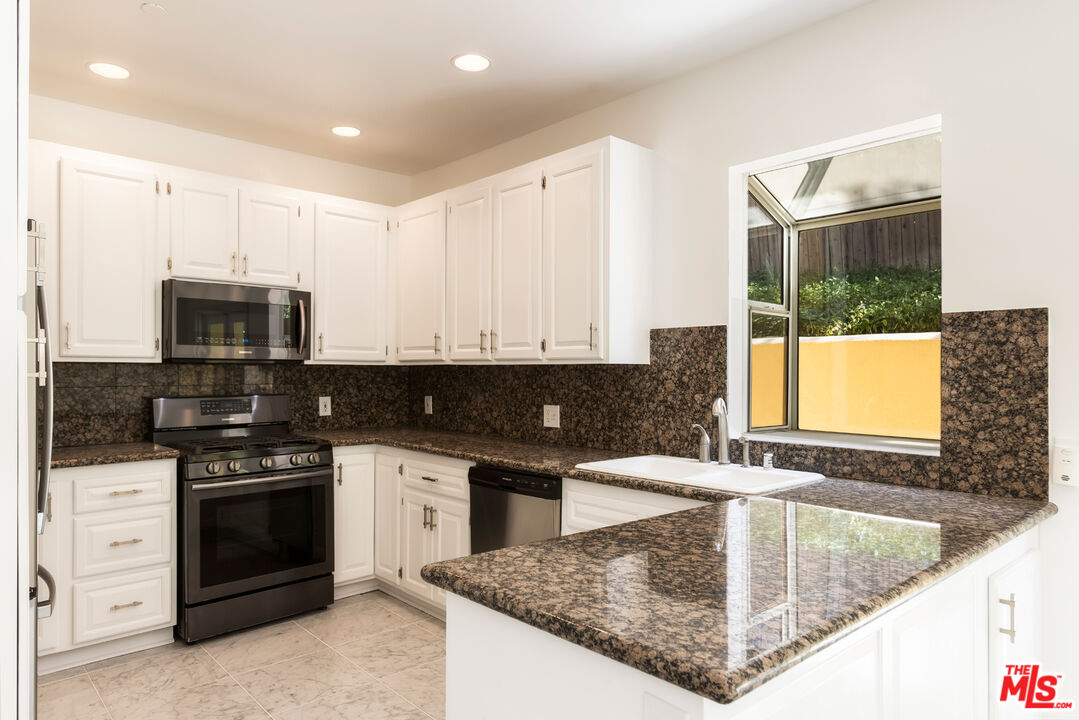 23636 Aster Trail Calabasas, CA 91302 - Photo 27 of 67 a kitchen with stainless steel appliances granite countertop a sink stove and microwave