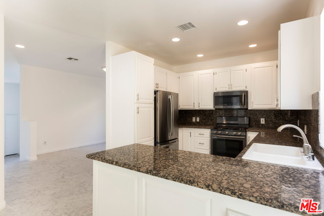 23636 Aster Trail Calabasas, CA 91302 - Photo 29 of 67 a kitchen with stainless steel appliances granite countertop a sink stove and refrigerator