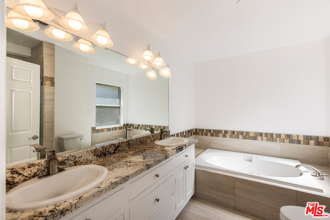 23636 Aster Trail Calabasas, CA 91302 - Photo 50 of 67 a bathroom with a granite countertop sink and a bathtub