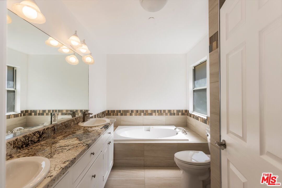 23636 Aster Trail Calabasas, CA 91302 - Photo 51 of 67 a bathroom with a granite countertop sink and a bathtub