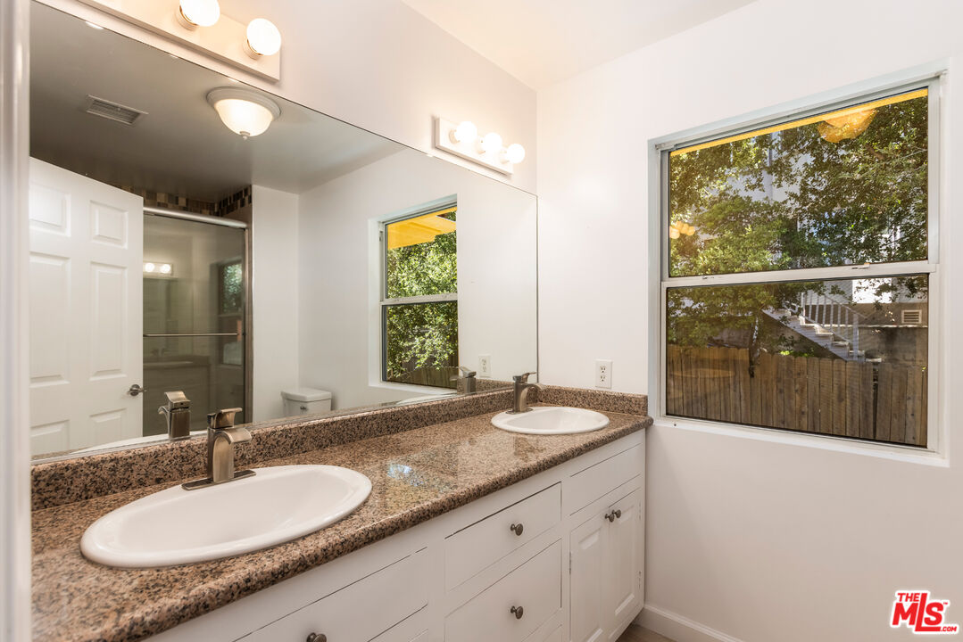23636 Aster Trail Calabasas, CA 91302 - Photo 59 of 67 a bathroom with a granite countertop sink and a mirror