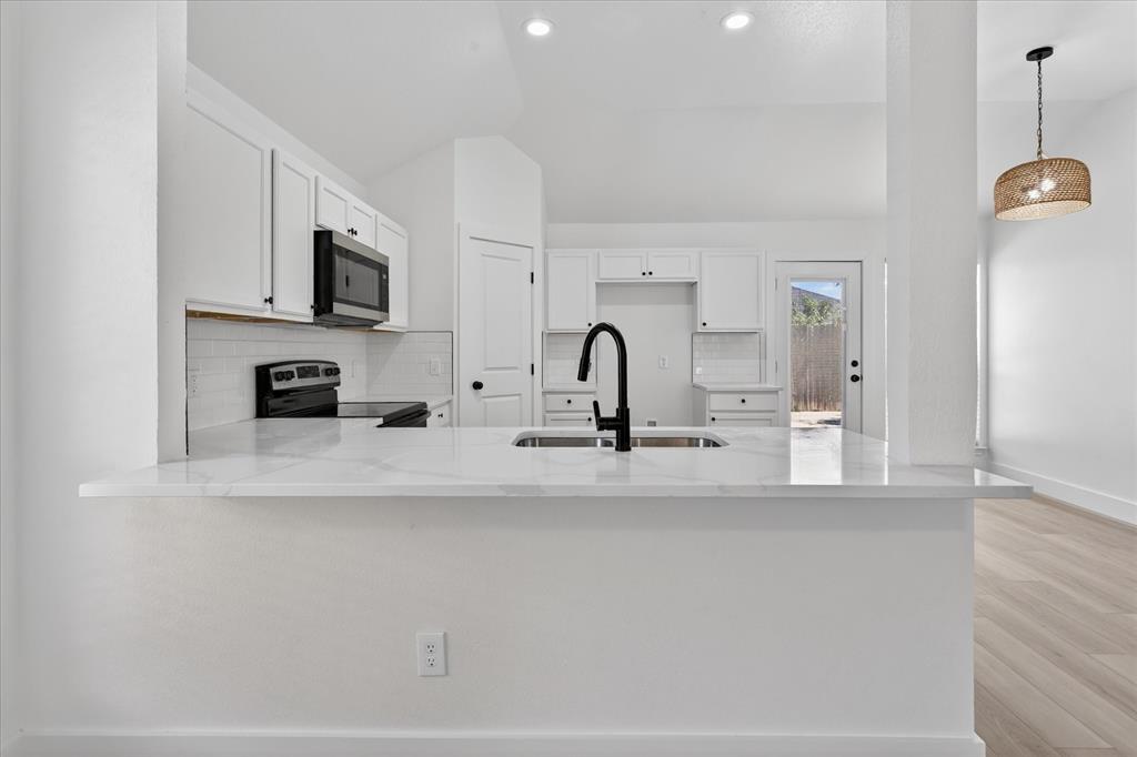 6021 Hartman Road Forest Hill, TX 76119 - Photo 10 of 27 a view of a kitchen with a sink a microwave and cabinets