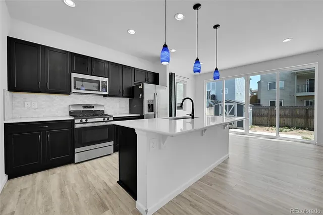 a kitchen with stainless steel appliances a refrigerator a stove a sink and a oven