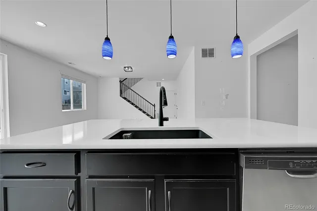 a kitchen with kitchen island a sink wooden floor and window