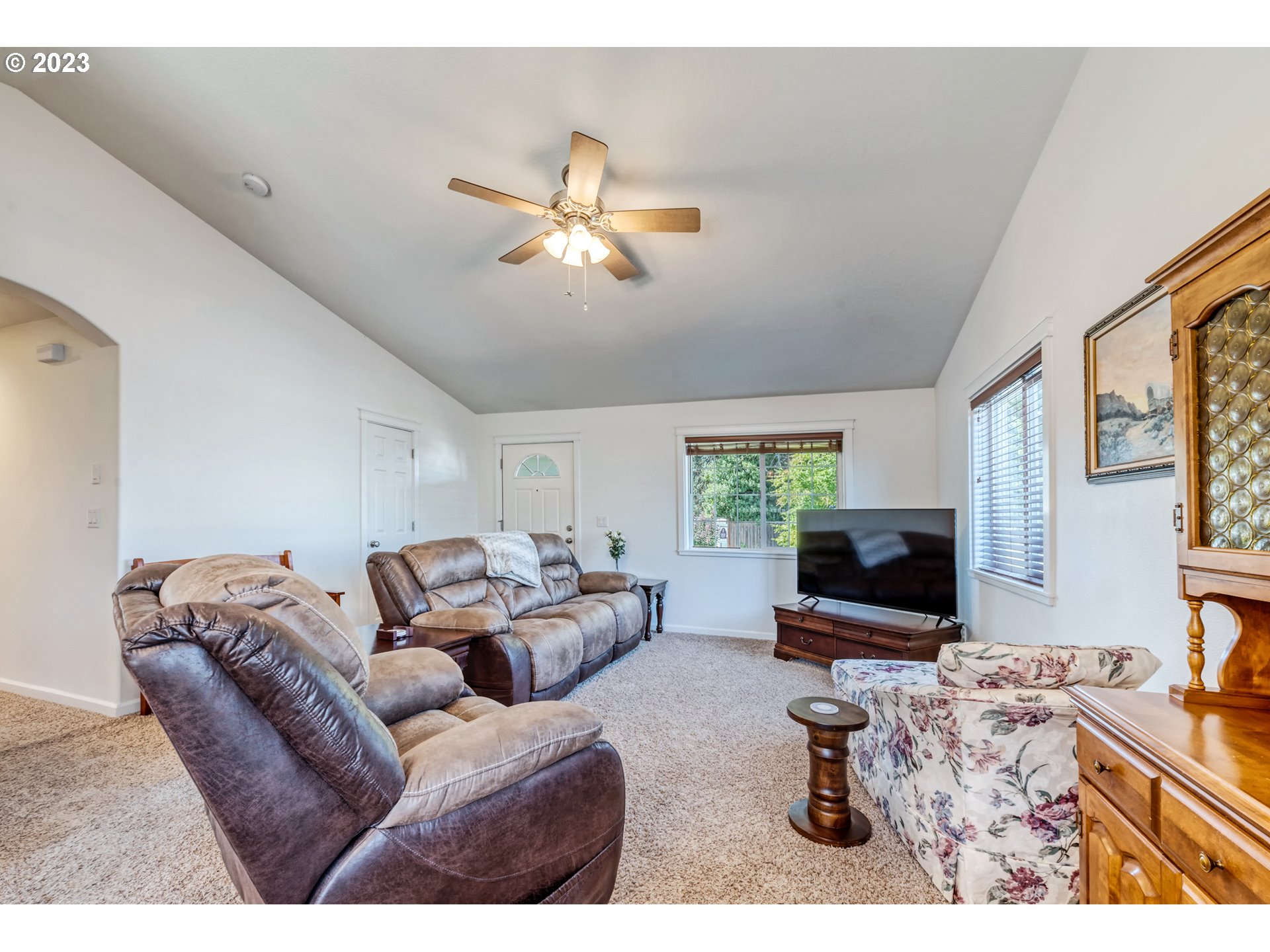 4659 Bluebelle Way Springfield, OR 97478 - Photo 6 of 32 a living room with furniture a flat screen tv and a fireplace