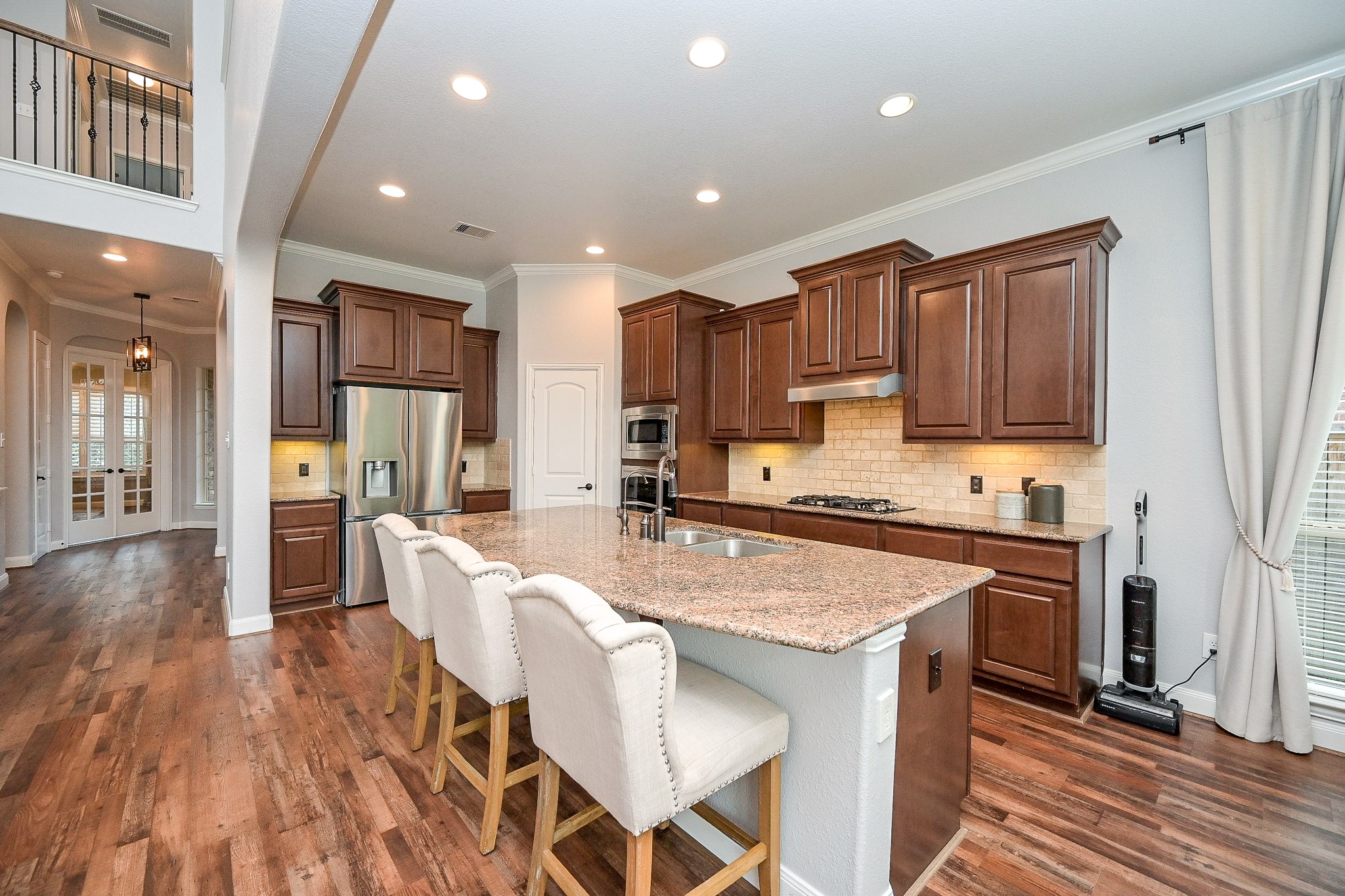 11 South Victoriana Circle Spring, TX 77389 - Photo 10 of 38 a large kitchen with stainless steel appliances granite countertop a stove a sink dishwasher and a refrigerator with wooden floor