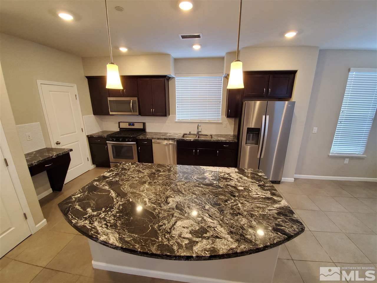 235 Mark Jeffrey Lane, Unit 101 Reno, NV 89503 - Photo 3 of 10 a kitchen with refrigerator and chairs