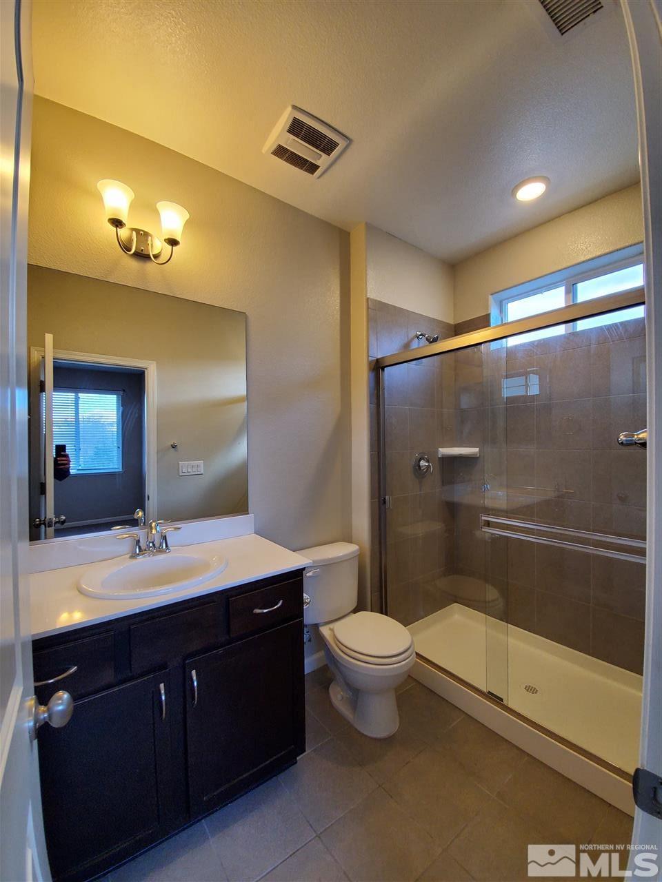 235 Mark Jeffrey Lane, Unit 101 Reno, NV 89503 - Photo 8 of 10 a bathroom with a bathtub shower sink mirror and toilet
