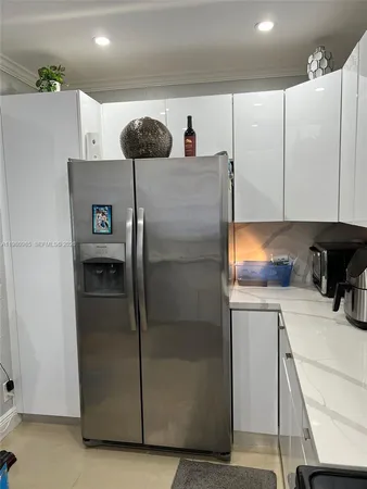 a kitchen with kitchen island wooden cabinets a stove top oven and stainless steel appliances