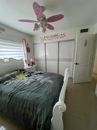 a bedroom with a bed and ceiling fan