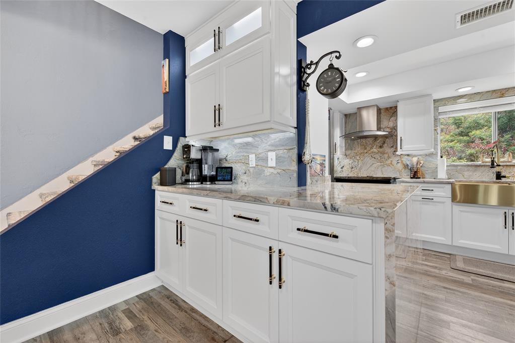 92 Alberta Avenue Ponce Inlet, FL 32127 - Photo 15 of 31 a kitchen with a sink dishwasher a stove and white cabinets with wooden floor