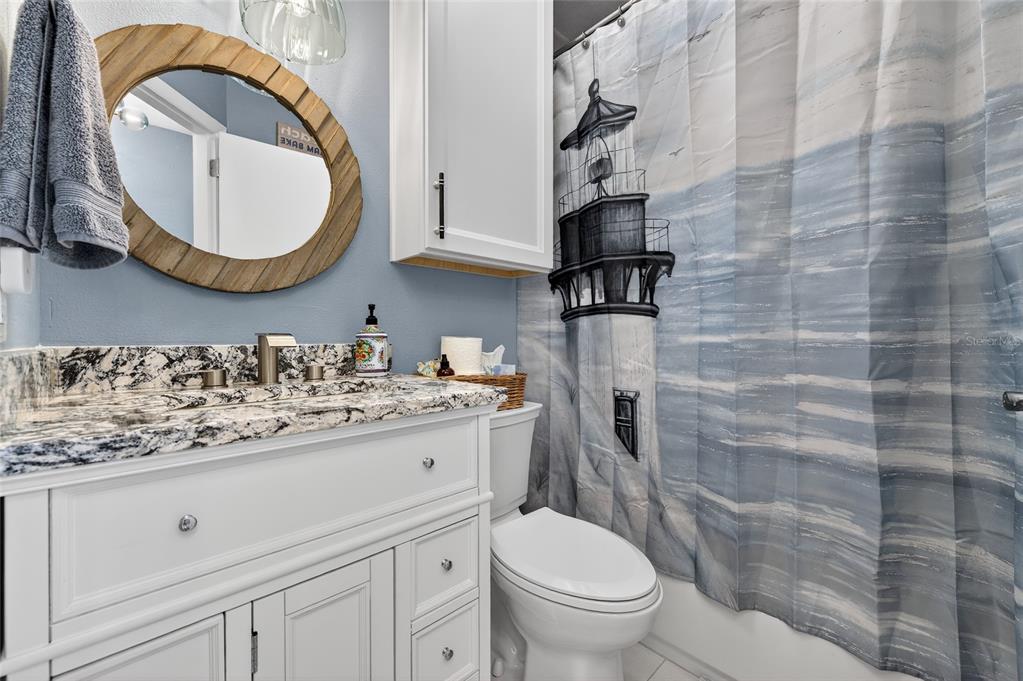 92 Alberta Avenue Ponce Inlet, FL 32127 - Photo 16 of 31 a bathroom with a granite countertop toilet sink and mirror