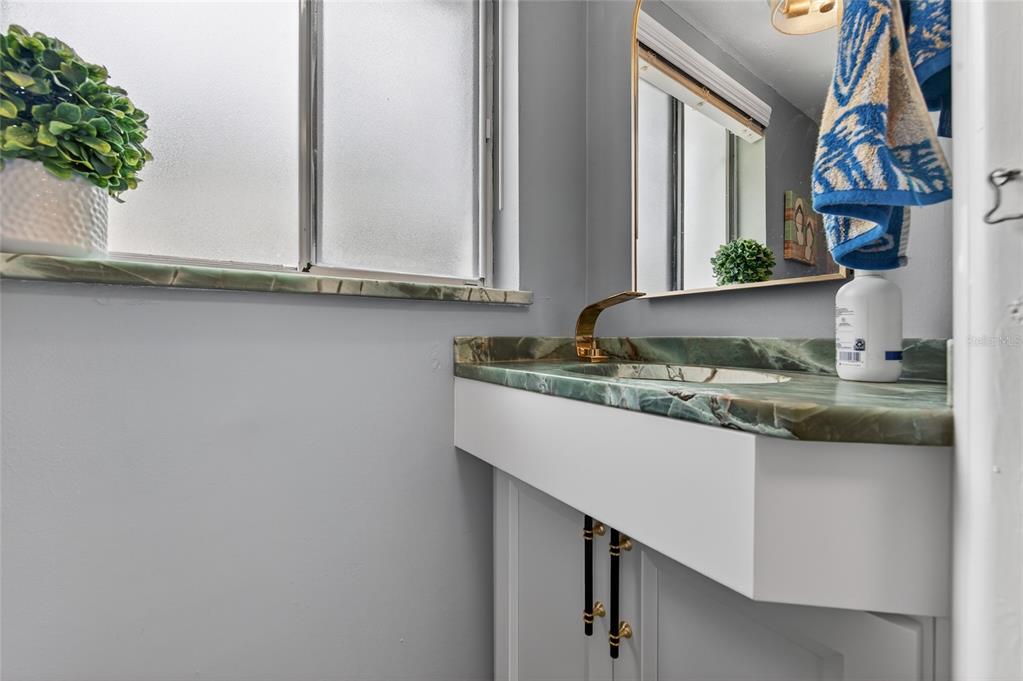 92 Alberta Avenue Ponce Inlet, FL 32127 - Photo 21 of 31 a bathroom with a granite countertop sink and a mirror