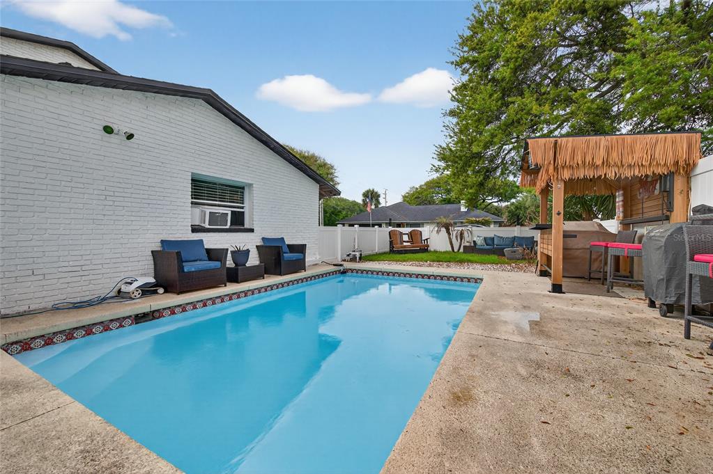 92 Alberta Avenue Ponce Inlet, FL 32127 - Photo 25 of 31 a view of a swimming pool with chairs