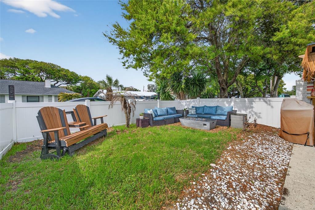 92 Alberta Avenue Ponce Inlet, FL 32127 - Photo 26 of 31 a view of a backyard with table and chairs potted plants and large tree