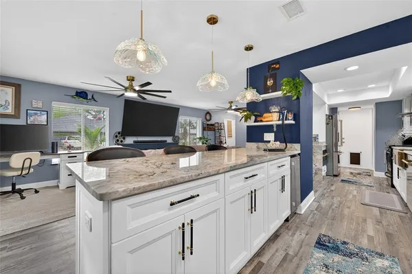 a kitchen with stainless steel appliances granite countertop a sink and dishwasher a refrigerator with wooden floor