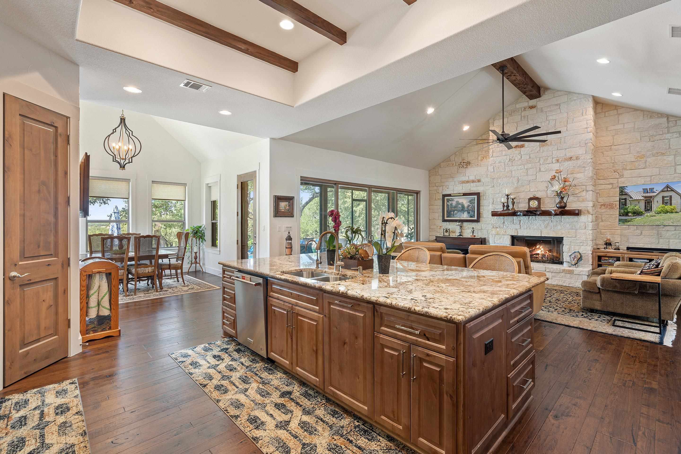 175 Scenic Ridge Drive Spicewood, TX 78669 - Photo 12 of 30 a large kitchen with kitchen island a large counter space a sink appliances and living room view