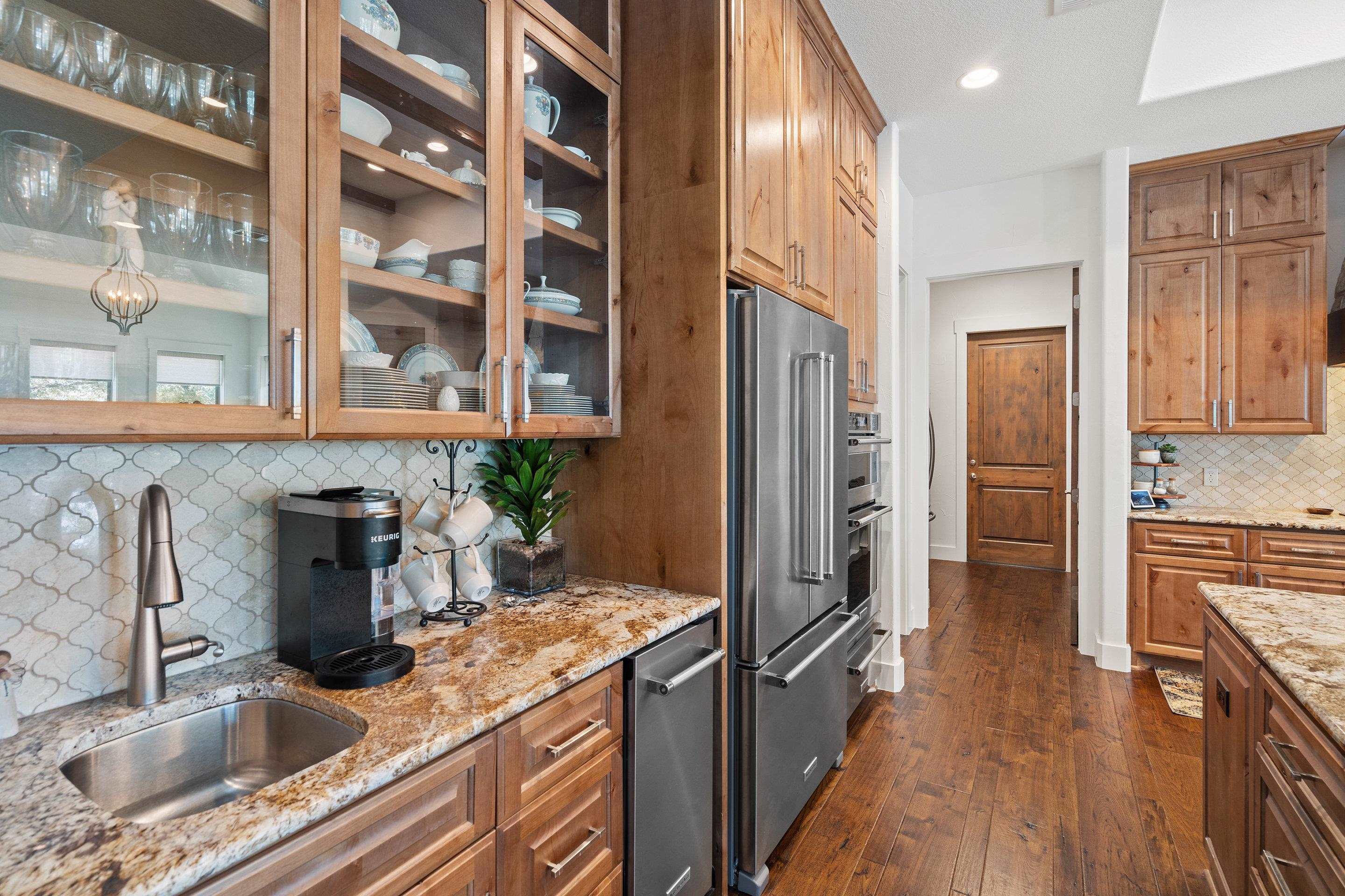 175 Scenic Ridge Drive Spicewood, TX 78669 - Photo 13 of 30 a kitchen with stainless steel appliances granite countertop a refrigerator and a sink