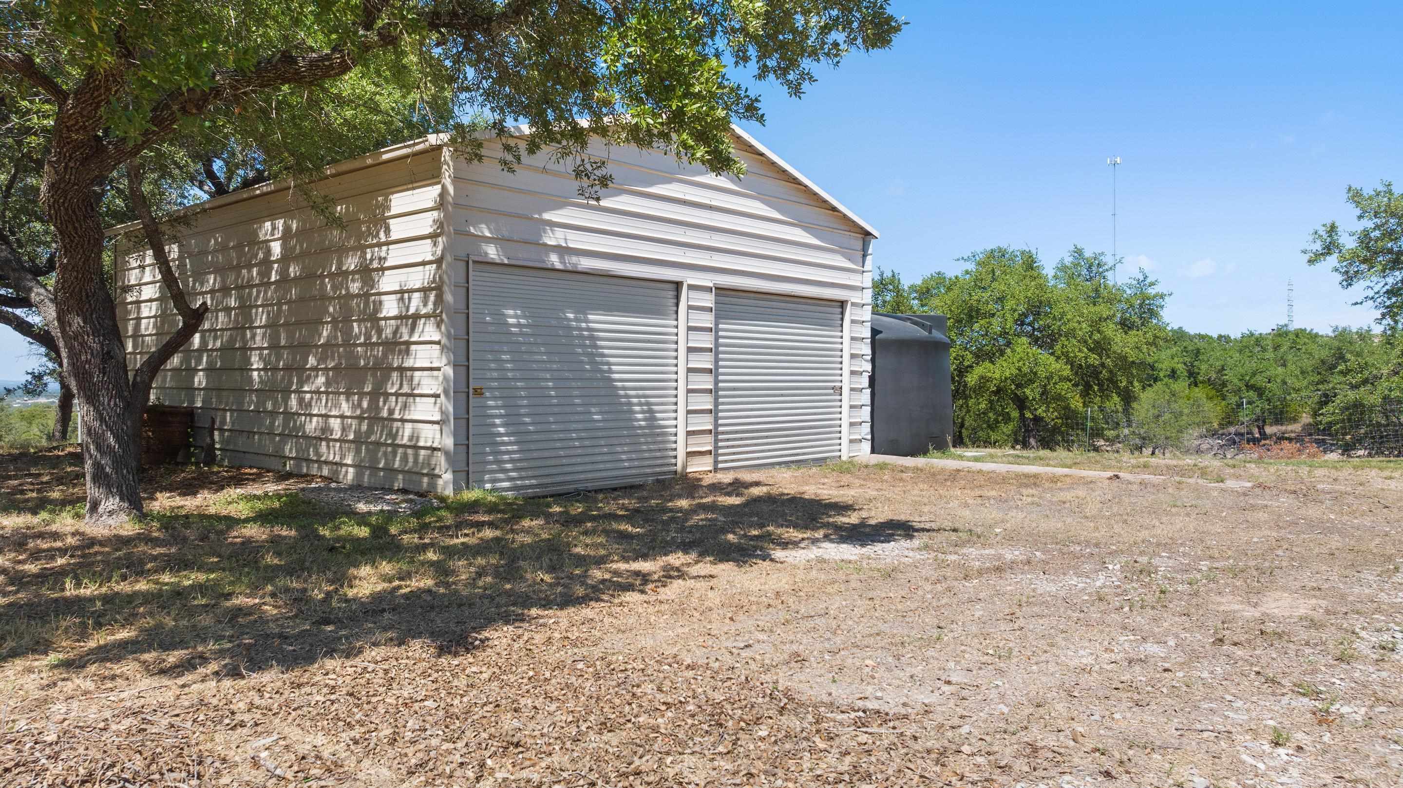 175 Scenic Ridge Drive Spicewood, TX 78669 - Photo 21 of 30 a view of a house with a yard and garage