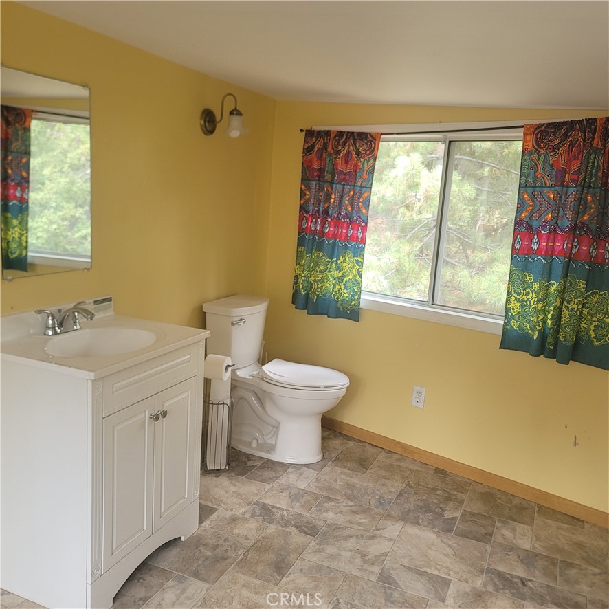 23340 Banning Idyllwild Idyllwild, CA 92549 - Photo 23 of 23 a bathroom with a toilet sink and window