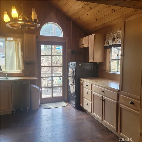 a kitchen with a wooden floor and white stainless steel appliances