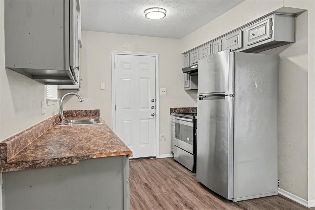 1321 North 7th Street Conroe, TX 77301 - Photo 9 of 17 a kitchen with refrigerator and countertop