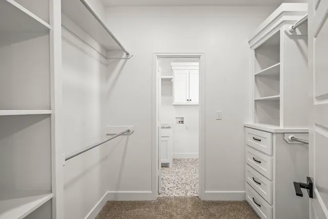 a view of walk in closet with empty racks