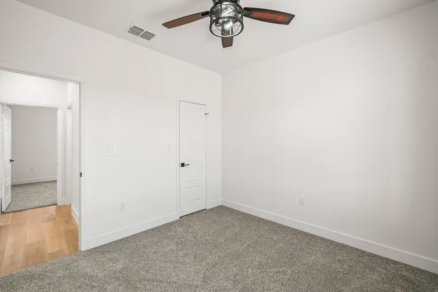 a view of a hallway with a chandelier fan