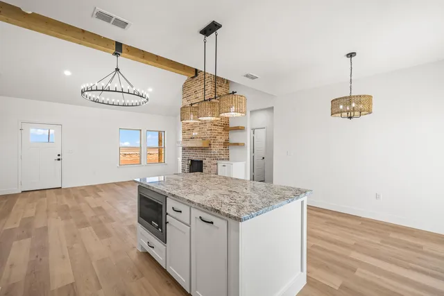 a kitchen with a wooden floor and a chandelier