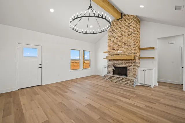 a view of an empty room with a fireplace and a window