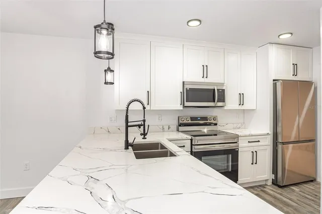 a kitchen with stainless steel appliances a refrigerator stove and microwave