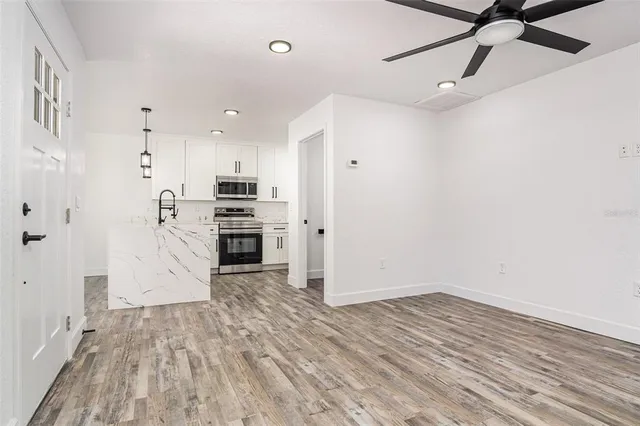 a view of a kitchen with a sink and dishwasher a refrigerator with wooden floor