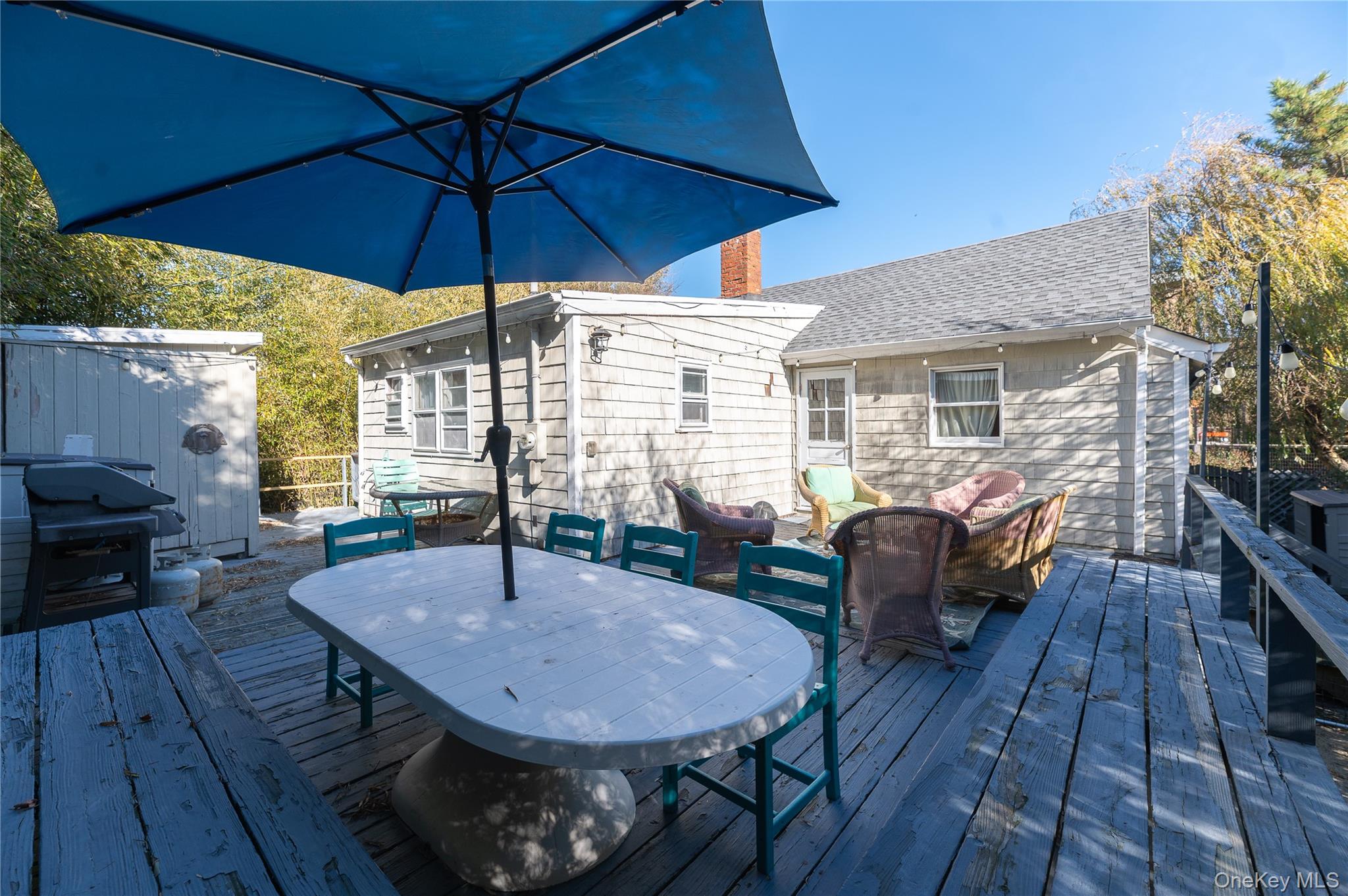 987 Surfview Walk Ocean Beach, NY 11770 - Photo 22 of 22 a view of a roof deck with table and chairs under an umbrella