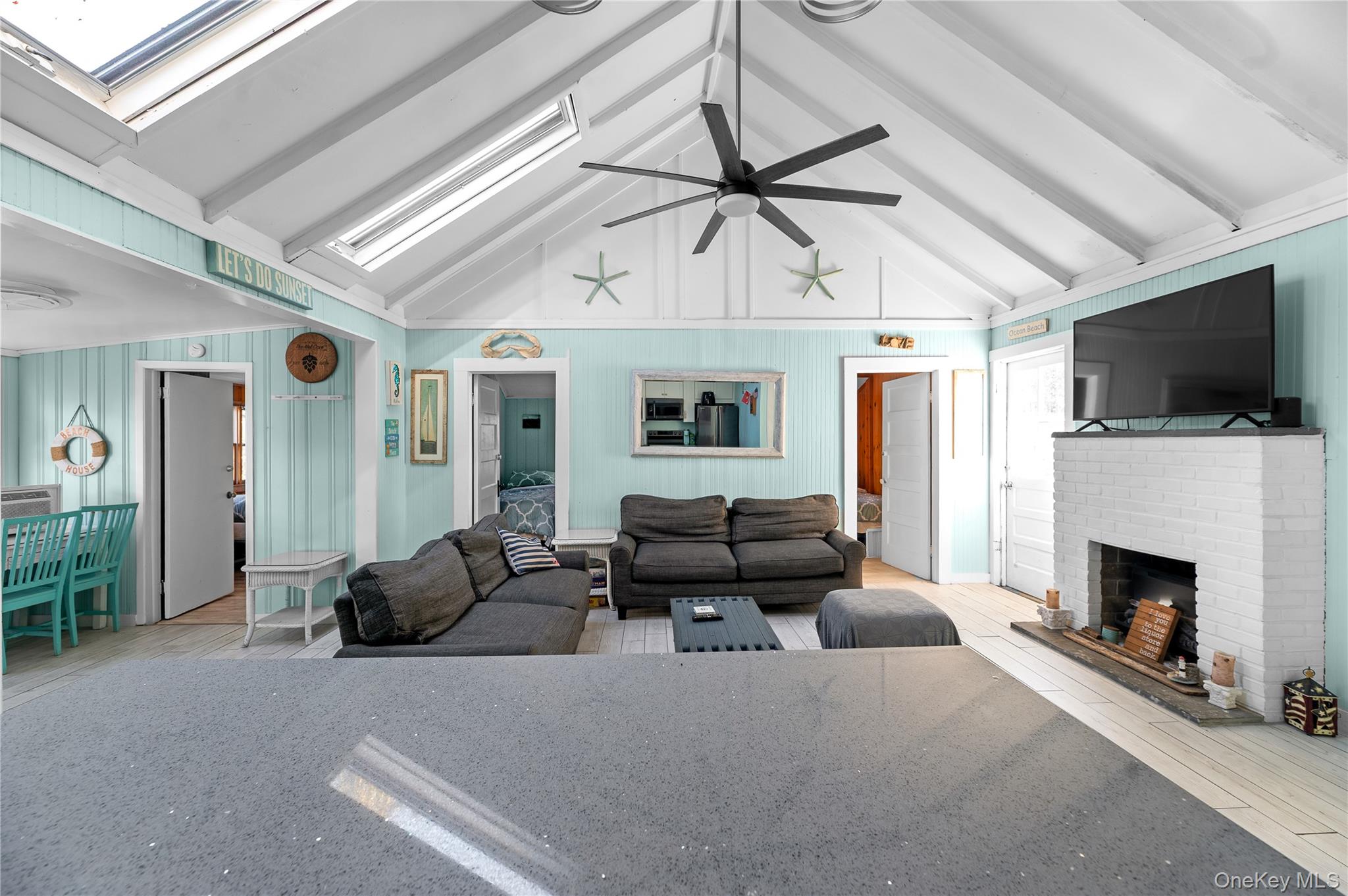 987 Surfview Walk Ocean Beach, NY 11770 - Photo 3 of 22 a living room with furniture a flat screen tv and a fireplace