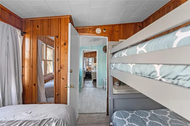 a bedroom with a bed and a large mirror on the dresser