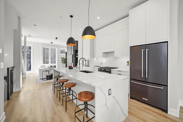 a kitchen with stainless steel appliances granite countertop a refrigerator a stove and a wooden floors