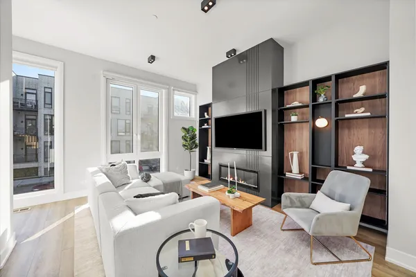 a living room with furniture a flat screen tv and a large window