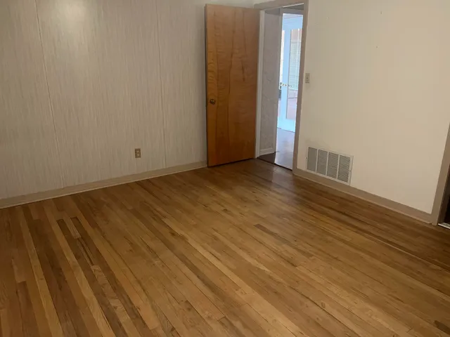 a view of a room with wooden floor