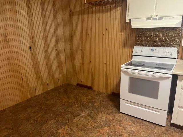 an empty room with wooden floor and entrance
