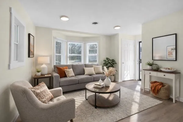 a living room with furniture fireplace and a large window