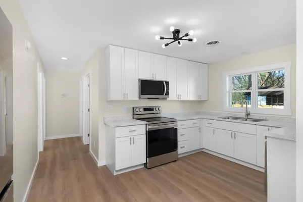 a kitchen with granite countertop appliances cabinets and a sink