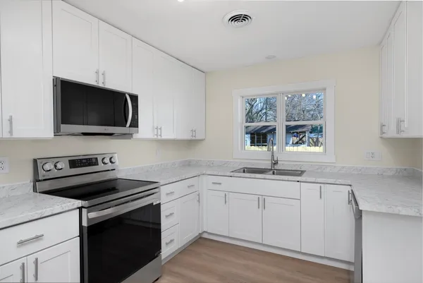 a kitchen with a sink stove and microwave